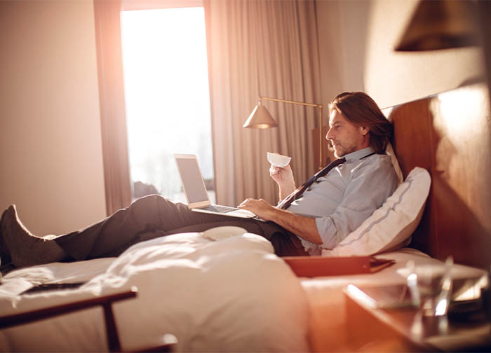 Man sitting on bed drinking coffee