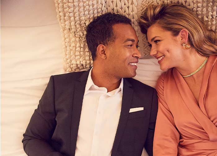 Couple laying down in bed at Atlantis